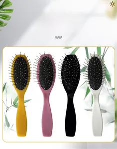 Close-up of colorful oval hairbrushes with steel pins and ergonomic handles for dry and wet hair