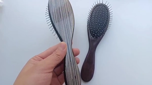 Detail of wooden massage hair brushes with metallic bristles and natural wood grain
