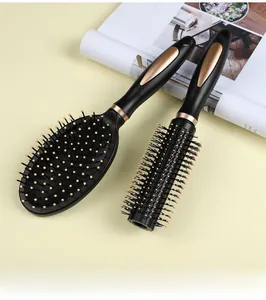 Detail of black and gold hair brush set featuring a paddle brush and a round styling comb