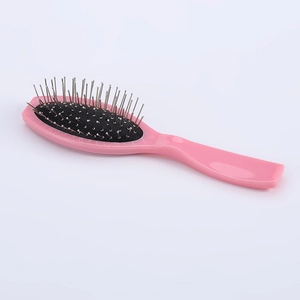 Oval pink hairbrush with stainless steel pins and air cushion on white background