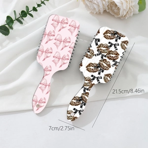 Pink leopard bow massage hairbrush set on silk background with size 21.5cm by 7cm