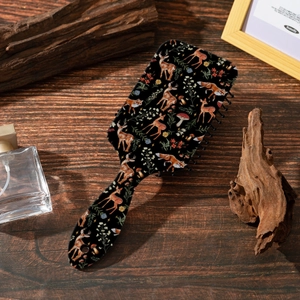 Detail of air cushion massage brush featuring forest animal prints on a wooden surface