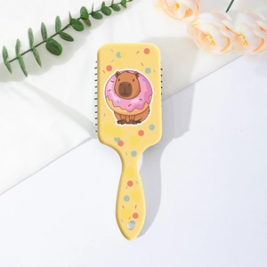 Détail de la brosse à cheveux jaune avec motif capybara mignon et trou de suspension
