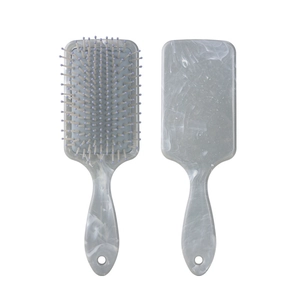 Detail view of square marble pattern hairbrush with purple massage bristles and ergonomic handle