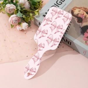Detail view of pink leopard bow print hairbrush on decorative aesthetic background