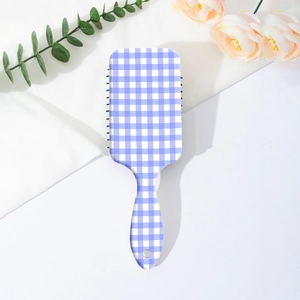 Detail of blue gingham pattern on back of paddle brush with soft fabric background