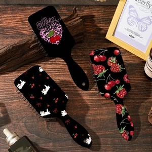 Brosses à cheveux à coussin noir avec motifs cerises et léopard sur bois sombre