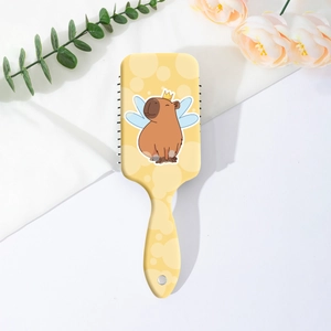 Détail de la brosse à cheveux carrée avec imprimé capybara mignon et poignée ergonomique
