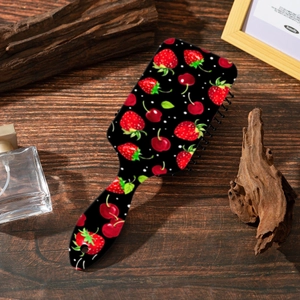 Dettaglio spazzola per capelli con stampa fragola e cuscino d'aria su legno