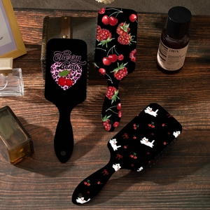 Lot de brosses à cheveux avec motifs cerises, cœurs léopard et chats sur table en bois
