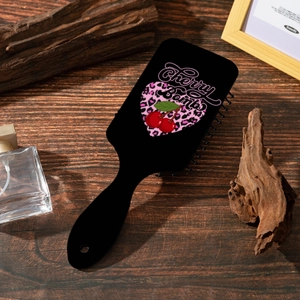 Détail d'une brosse noire avec imprimé cœur Cherry Bomb sur un fond en bois vintage