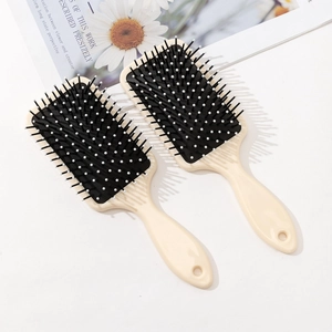Capybara print air cushion massage hairbrush with ergonomic cream handle on floral background