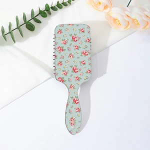 Dettaglio spazzola per capelli con cuscino d'aria e fiori di rose rosse