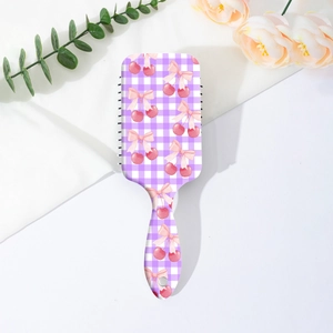 Vue détaillée d'une brosse à cheveux à carreaux violets avec motifs cerises et nœuds roses