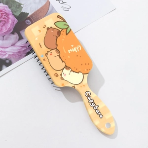 Détail de la brosse à cheveux massante Capybara avec dents larges et accents orange