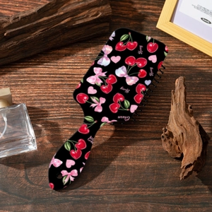 Dettaglio della spazzola per capelli con stampa fragola su superficie di legno