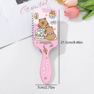 Macro detail of pink Capybara air cushion hairbrush showing soft bristles and floral decor