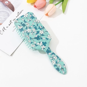 Floral print hair cushion brush with small white flower pattern and mint green handle