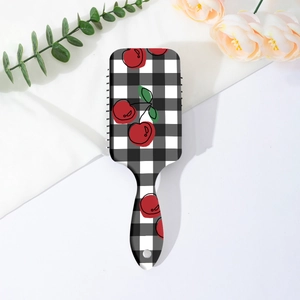 Detail of cherry plaid hairbrush showing the printed handle and storage hanging hole