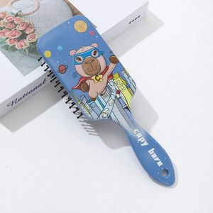 Detail view of blue rectangular air cushion brush featuring superhero capybara illustration