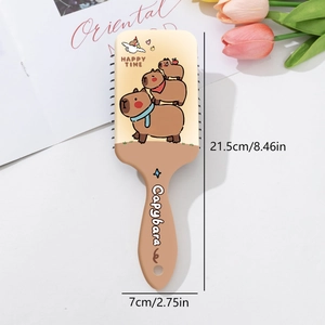Detail view of Capybara hairbrush with dimensions 21.5cm by 7cm on white desk