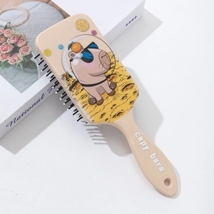 Detail of Capybara astronaut paddle brush showing the printed back and massage bristles
