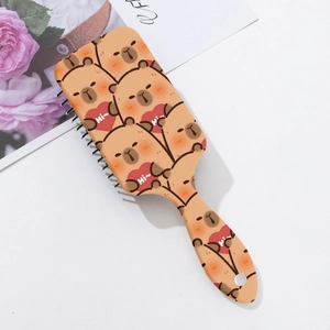 Détail macro d'une brosse à cheveux rectangulaire brune avec ours et motif de coeur