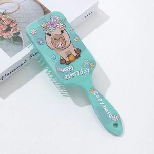 Macro detail of mint green hairbrush back featuring cute cartoon capybara and flowers