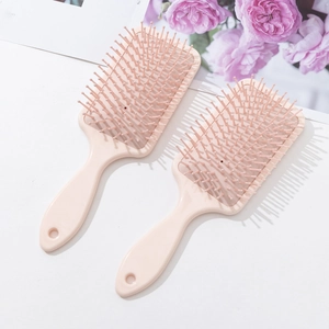 Set of two pink 3D floral paddle hairbrushes with air cushions on white floral background