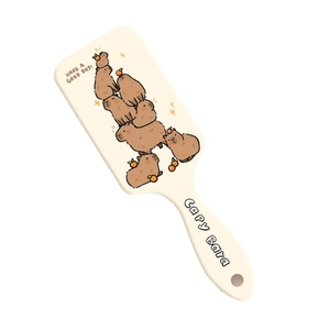 Creamy beige air cushion hair brush featuring cute cartoon capybara prints for scalp massage