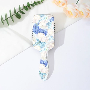 Detailed view of floral hairbrush handle with ergonomic grip and blue flower patterns
