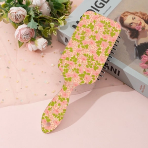 Detailed view of rectangular hairbrush featuring pastoral floral patterns and massage pins