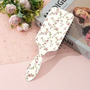 Detail view of pink floral pattern on rectangular cushion hairbrush with a hanging hole