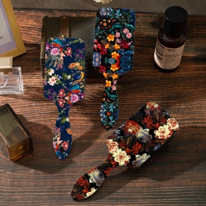 Vintage floral hairbrush set with air cushion on a wooden background for detangling