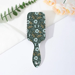 Close-up of vintage floral paddle brush on white fabric with eucalyptus leaves