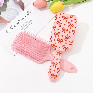 Pink hair brush set with cute bow and heart print featuring massage air cushion bristles