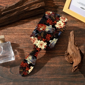 Detail of vintage floral pattern on paddle brush back with a rustic wooden background