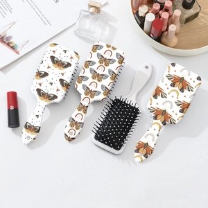 Set de brosses à cheveux à imprimé papillon bohème avec picots de massage sur table blanche