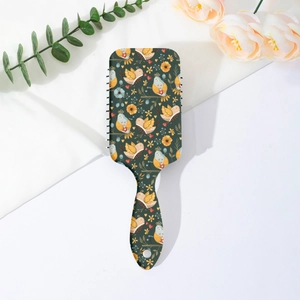 Detail of floral paddle brush with bird patterns and green bohemian handle design
