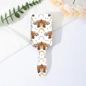 Détail de l'imprimé papillon bohème sur brosse à cheveux blanche à coussin d'air et picots
