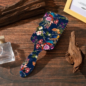 Detailed close-up of floral and parrot print on a rectangle vintage hair brush