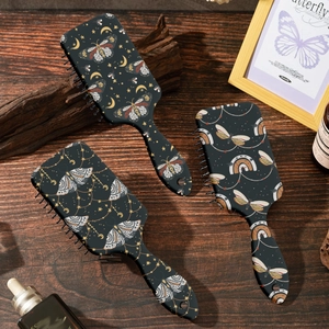 Three-piece retro moth and butterfly printed air cushion hairbrushes on dark wooden desk