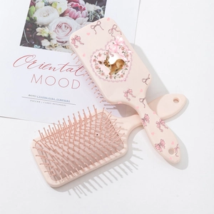 Pink paddle hairbrush set with deer and bow print on a floral heart frame background