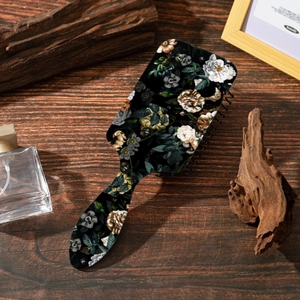 Detail of floral printed air cushion hairbrush on a rustic wooden background