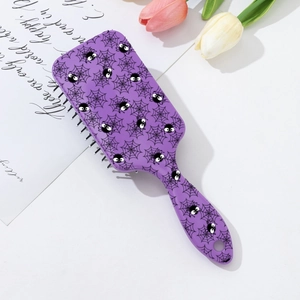 Détail de la brosse à cheveux Halloween violette avec motifs d'araignées sur le bureau
