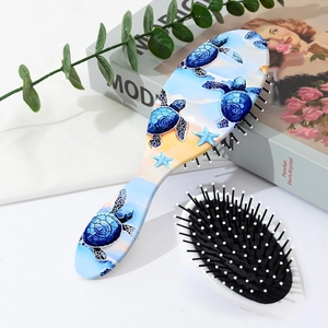 Close-up of hairbrush back with blue sea turtle and starfish ocean pattern prints
