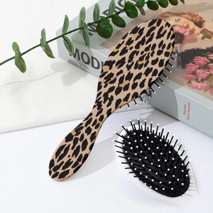 Detailed close-up of leopard print hairbrush with anti-static air cushion and soft massage tips