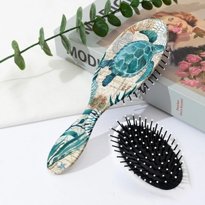 Detailed view of the ocean-themed turtle print and massage bristles on the paddle brush