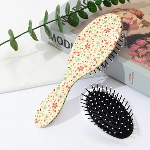 Détail des brosses à cheveux à coussin d'air fleuries avec dos à motifs et picots massants