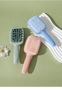 Close-up of silicone scalp massage brushes and combs in pastel pink, blue and green